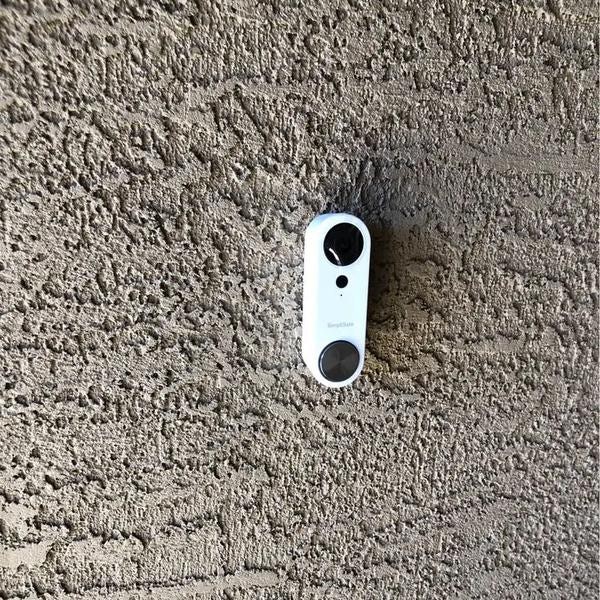 White SimpleSafe Doorbell installed on stucco