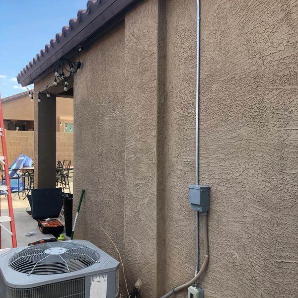 Covered outdoor outlet next to AC unit.