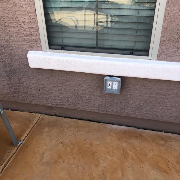 Covered outdoor outlet under window.